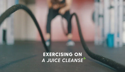 Blurred image of a person using battle ropes in a gym with the text “Exercising on a Juice Cleanse” overlaid.
